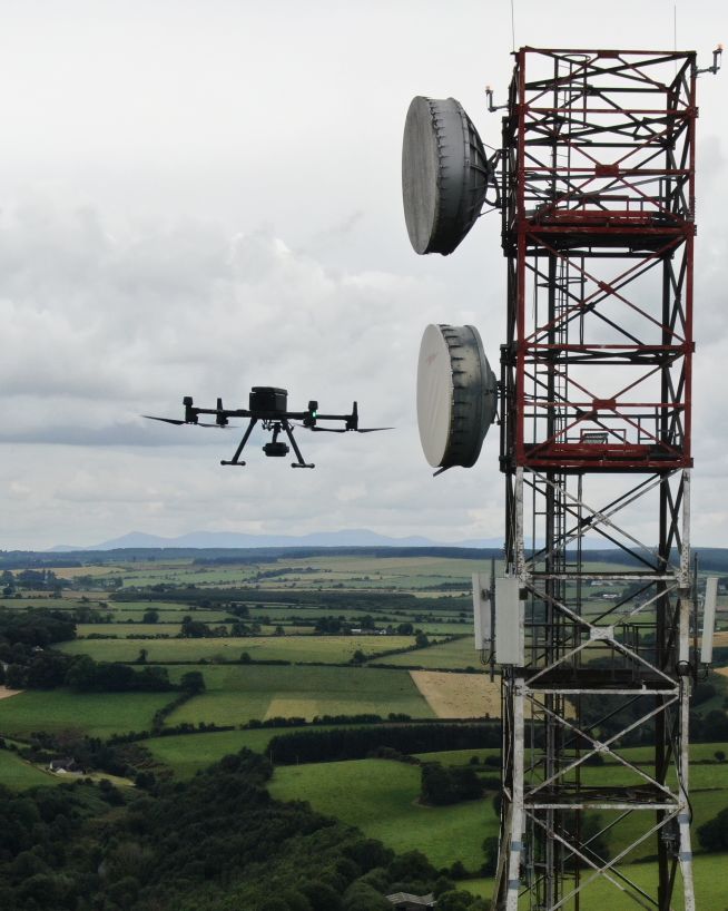 A drone performing an inspection of a communications tower