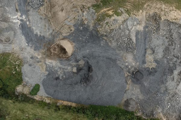An overhead view of separated aggregate stockpiles in a working yard