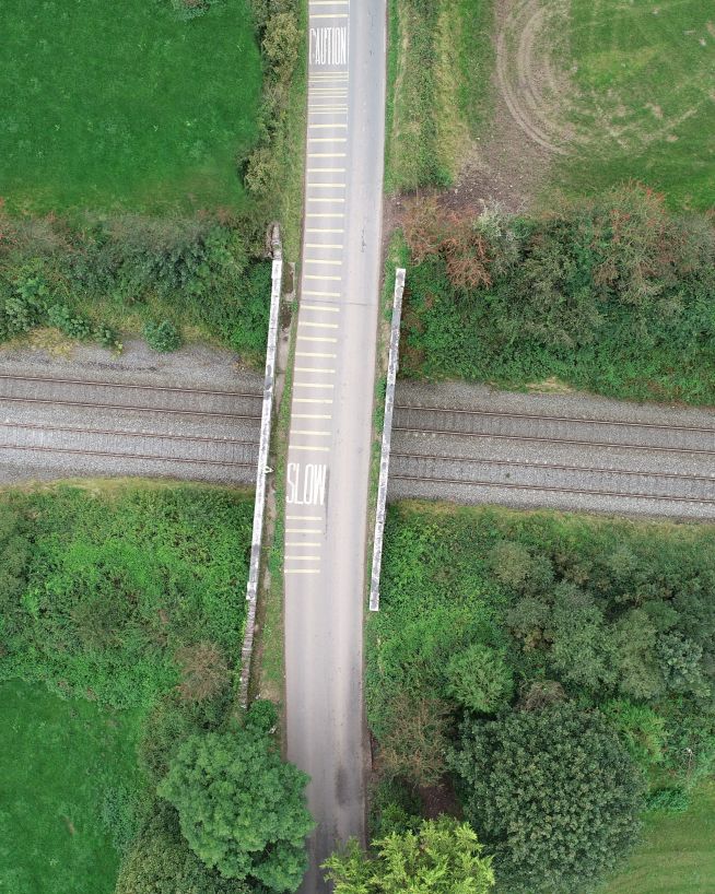 A photo of a railway tracks and a bridge taken with a drone