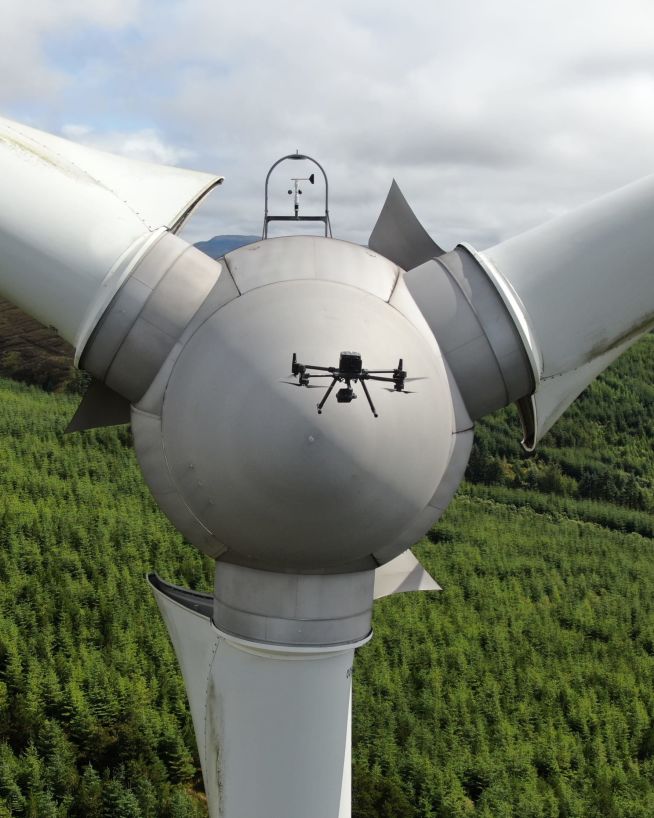 A drone performing a wind turbine inspection